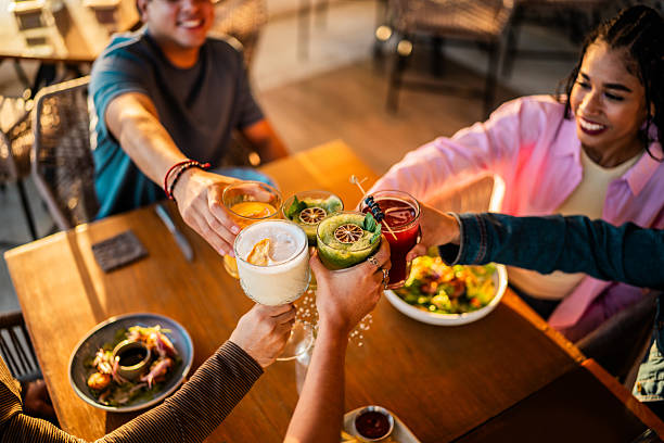 Close-up of young friends toasting drinks at restaurant