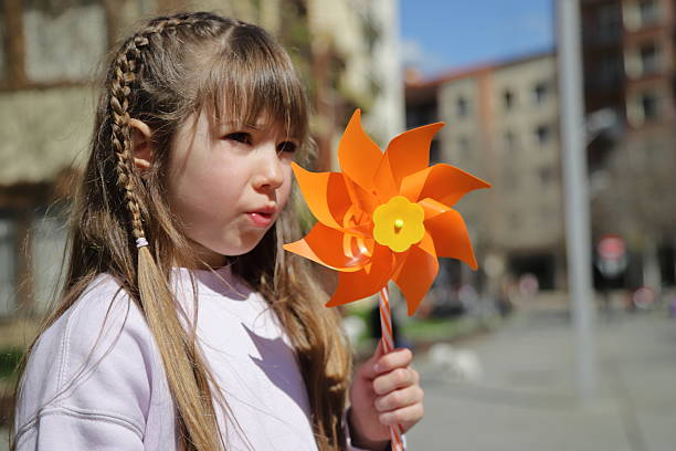 Little girl with pinwheel, playing outside, lifestyle