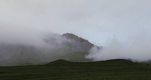 istock Rocky mountain peaks covered with clouds at dusk 2209360869