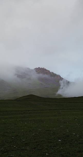 istock Rocky mountain peaks covered with clouds at dusk 2209360896