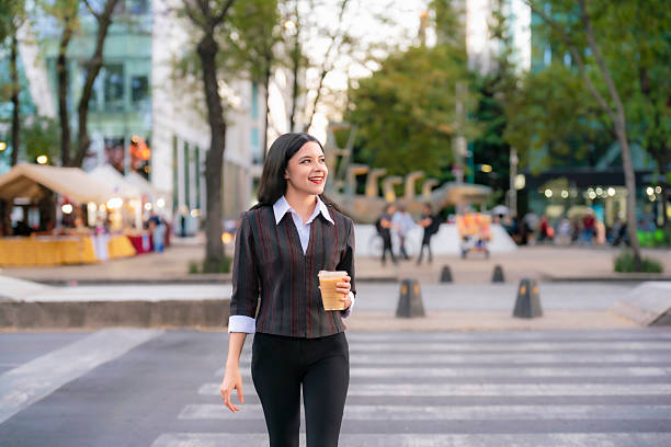 Latina woman smiling while crossing Reforma with coffee