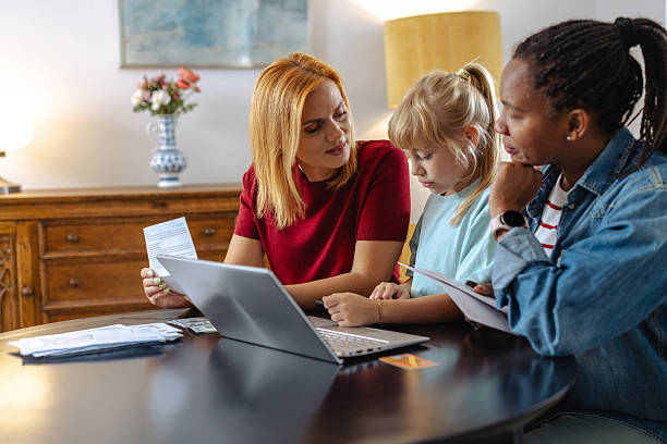 istock Smiling family discussing together around a table with a laptop and documents 2209362366