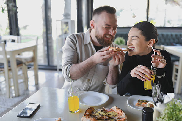 istock Boyfriend Sharing Pizza With Hungry Girlfriend Both Smiling and Looking Happy 2209364146
