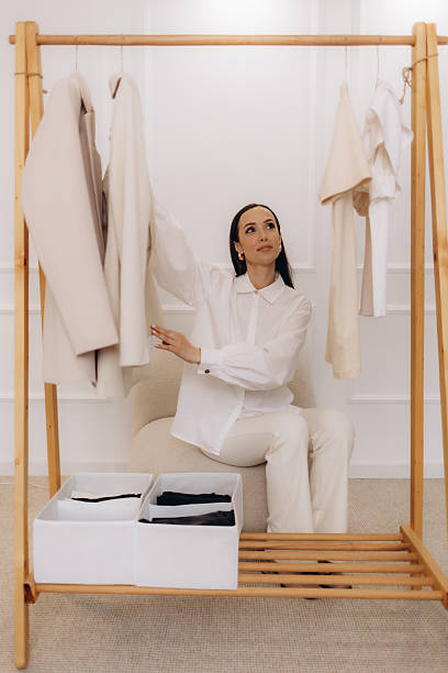 istock A smiling middle-aged woman selecting clothes in a bright wardrobe room, denoting a casual shopping or dressing scenario. 2209368904