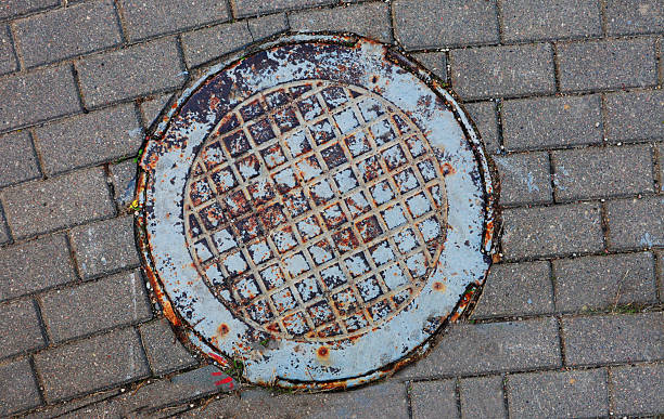 istock Metal sewer manhole in the sidewalk. 2209370431