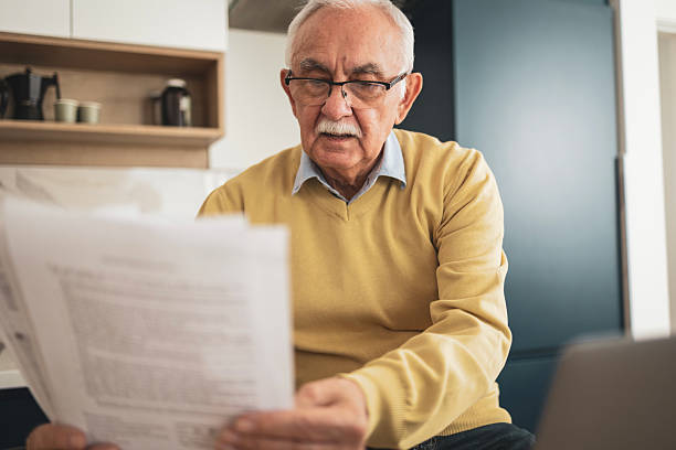 istock Senior man working at home on laptop while enjoying a cup of coffee 2209370656