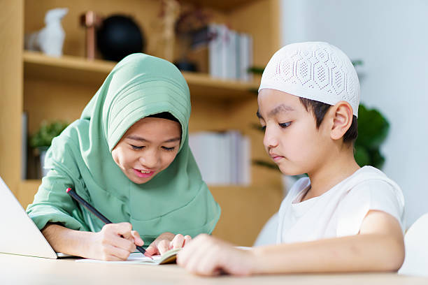 istock Asian muslim sibling are study and do homework at home. 2209378392