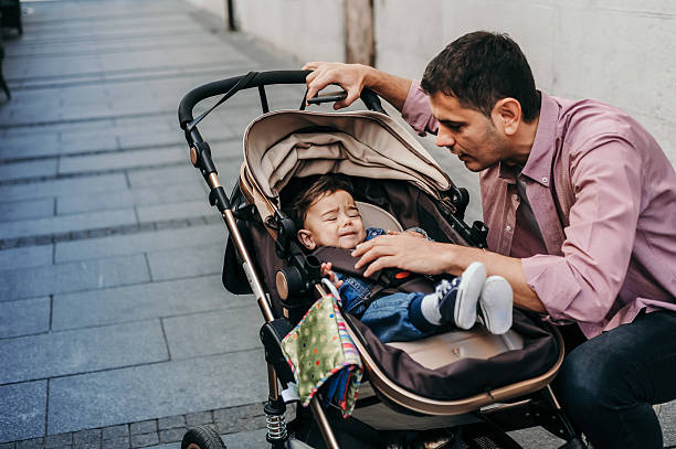 istock Father Comforting Baby in Stroller on a City Walk 2209382803