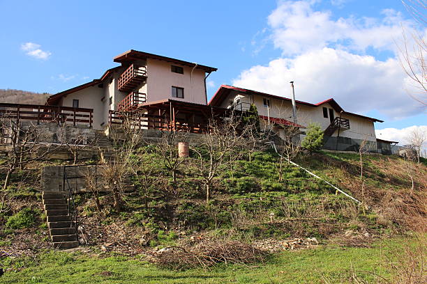A house behind a fence. Sky. Outdoor. Grass. Building. House