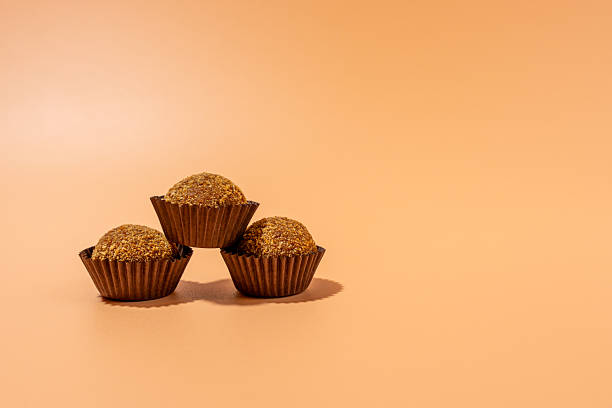 istock Three brown cupcakes stacked on top of each other 2209390236