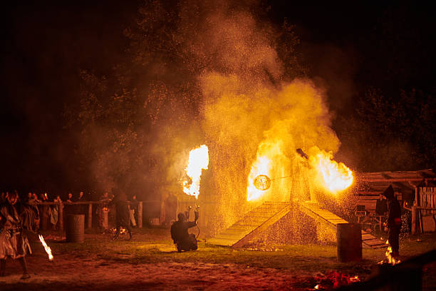 Kaliningrad, Russia - 10.09.2022 - Silhouette of fire performers with sparkling fire staff erupting in night sky, showcasing energy and artistry of fire manipulation during an outdoor fire show