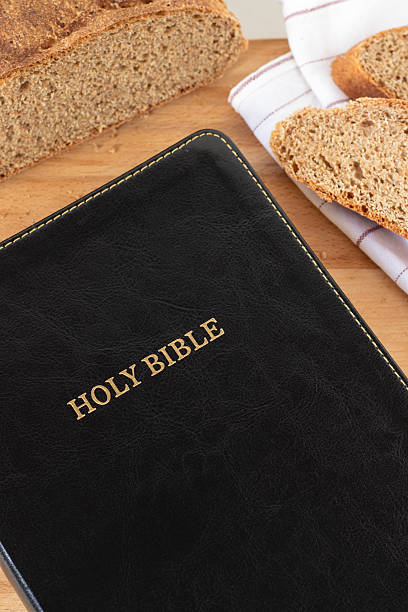 istock Holy bible book and bread on wooden table 2209391622