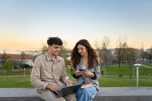 istock Business interns using laptop in public park 2209394449