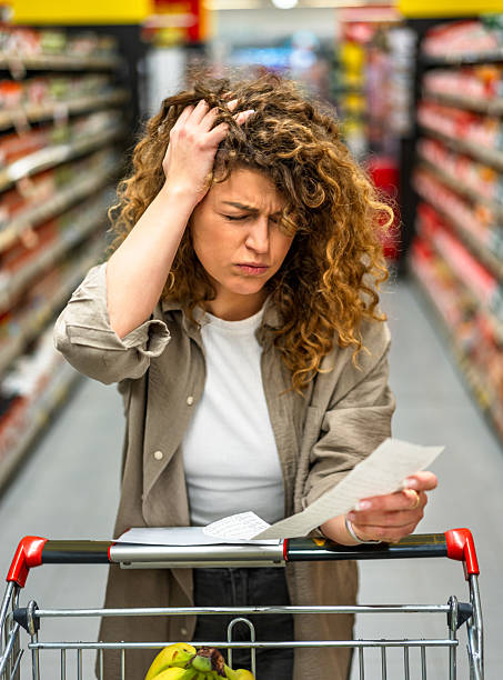 istock Woman feeling concerned about grocery prices on the bill 2209394648