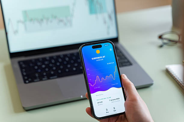 istock Close-up of a businessman analyzing cryptocurrency market using a smartphone and a laptop 2209396130