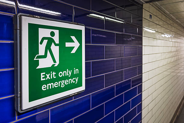 istock Emergency Exit Sign on Blue Tiled Wall in London Underground Station 2209397441