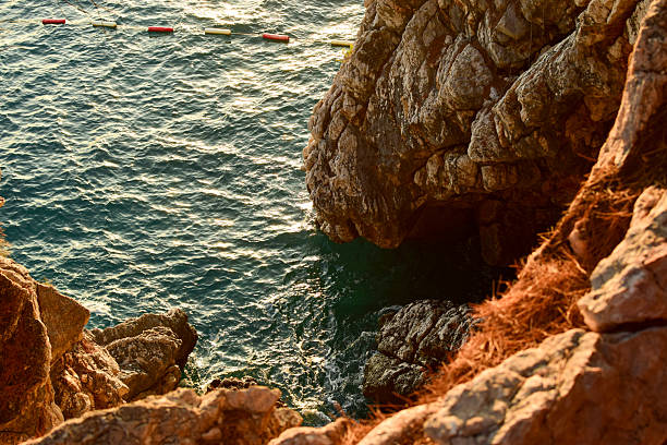 istock Rocky Coastal Cliffs with Floating Sea Markers 2209399943