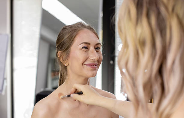 istock Professional Make-up artist doing makeup for smiling woman. 2209400162