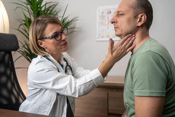 istock Doctor doing throat examination on mature man 2209401381