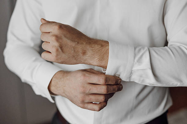 istock A man is wearing a white shirt and is adjusting his sleeve 2209402787