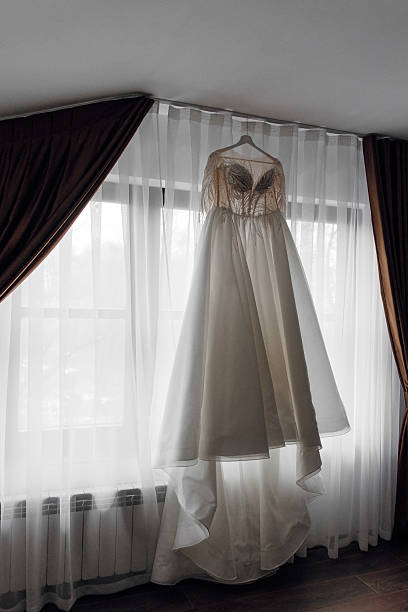 istock A white dress hanging from a clothesline in a window 2209402882
