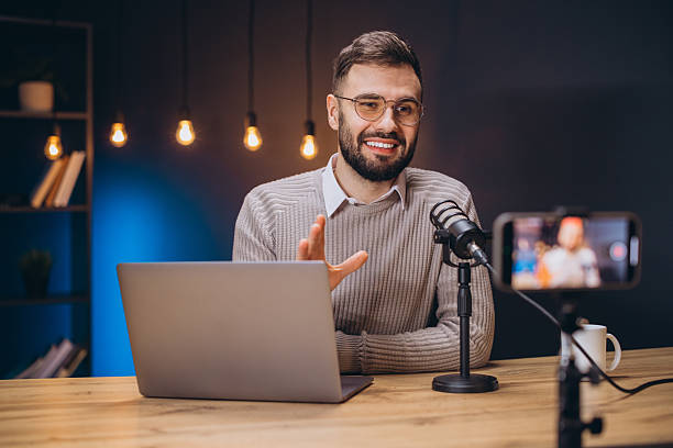 istock Young podcaster speaking and gesturing during a live stream or video recording in his studio 2209403006