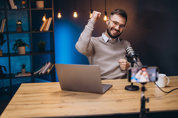 istock Happy podcaster celebrating success while recording a new episode in a professional studio 2209403007