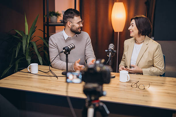 istock Content creators recording podcast episode using professional microphone and video camera in modern studio 2209403039