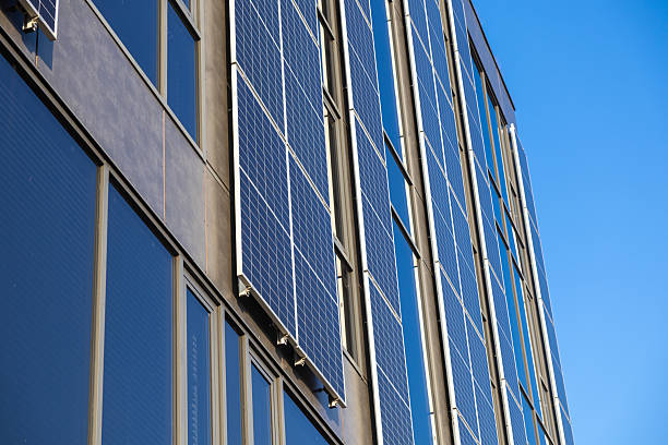 Solar panels installed on tall modern building reflecting clear blue sky renewable energy and sustainable urban architecture background