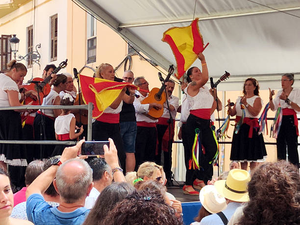 Crowd of people watching folk concert on the streets of Malaga for the Feria de Agosto 2024 (August Fair) or Feria de Málaga, a street fair that takes place every August. Andalusia, Spain.