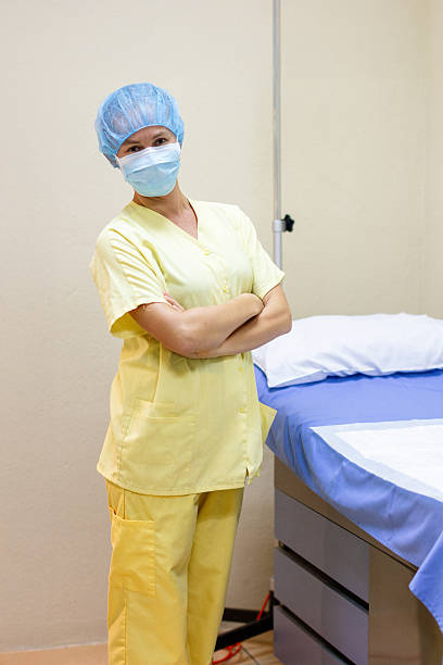 istock Nurse Wearing Protective Mask in Hospital Room 2209406333