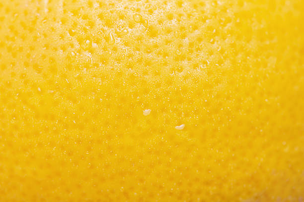 istock Lemon with water drops macro photo as background. Lemon skin is yellow, thin focus part. 2209410106