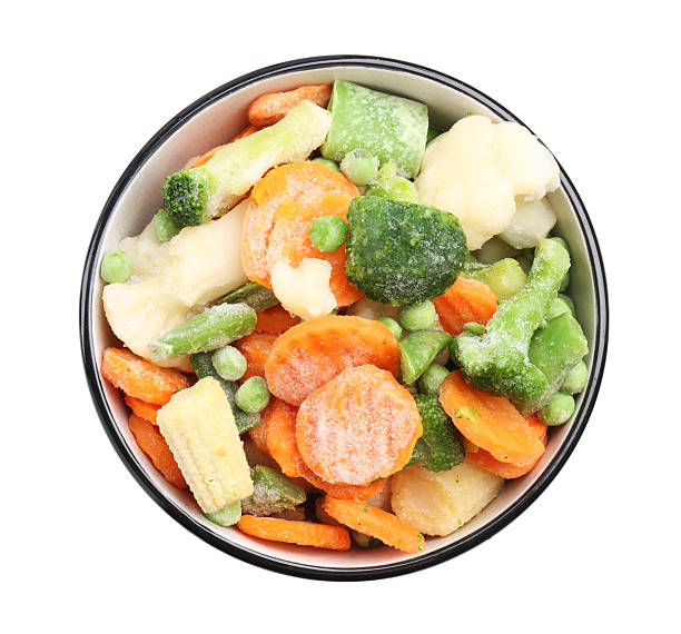 istock Different frozen vegetables in bowl isolated on white, top view 2209411148