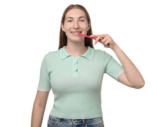 istock Girl with braces cleaning teeth on white background 2209411256