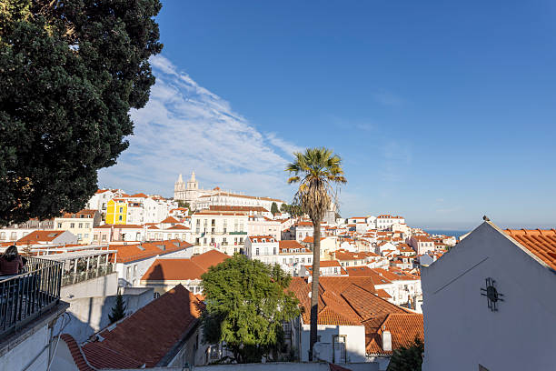 December 24, 2022, Lisbon Portugal. A sunny view of Lisbon's traditional red rooftops and blue sky, highlighting the city's beauty and architectural heritage.
