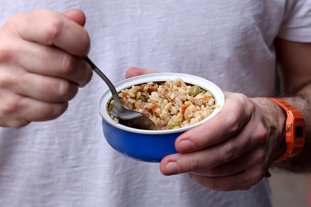 Man eats canned food spoon