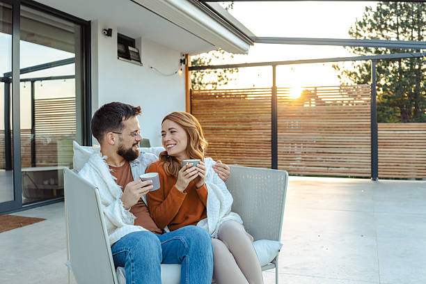 istock Couple enjoying coffee while relaxing on a modern outdoor balcony at sunset 2209415206