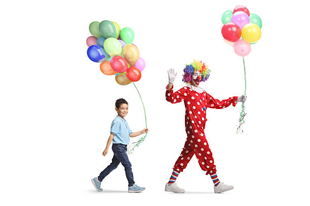 Boy and clown holding balloons and walking isolated on white background