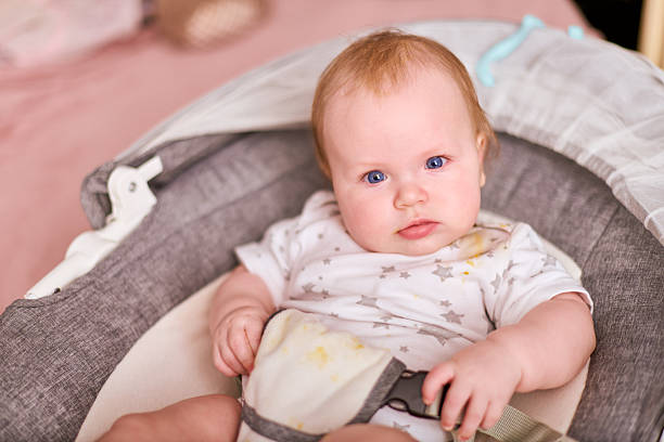 istock Baby in high chair awaiting feeding, soft lighting 2209416182