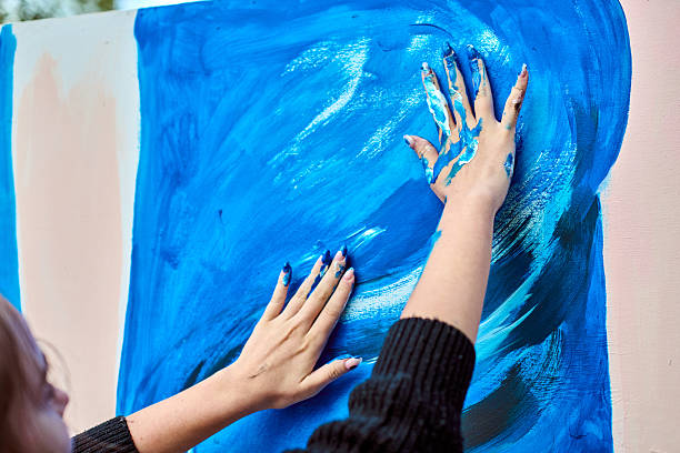 istock Hands creating art with vivid blue paint 2209416257