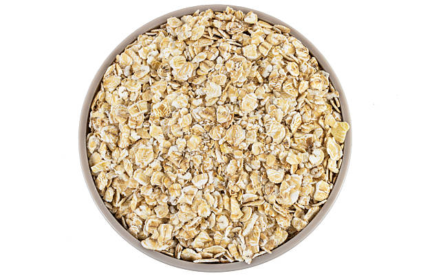 istock Bowl of raw oats on white background 2209416459