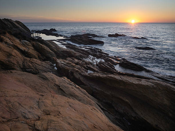 istock Sun rising over rocky coastline and ocean pool 2209417968