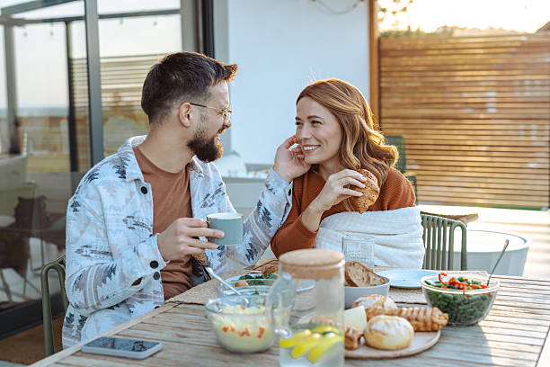 istock Couple enjoying breakfast outdoors on a sunny patio 2209418242