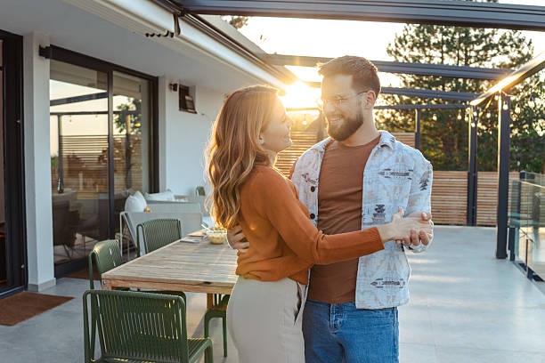 istock Joyful couple dancing together on a sunny modern patio 2209418250