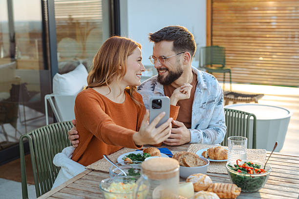 istock Smiling couple takes a selfie while sharing a lovely outdoor breakfast experience 2209418477