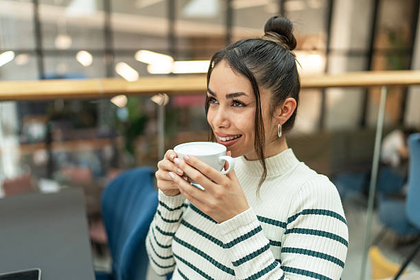 istock Relaxed woman enjoying coffee break in modern office 2209418799