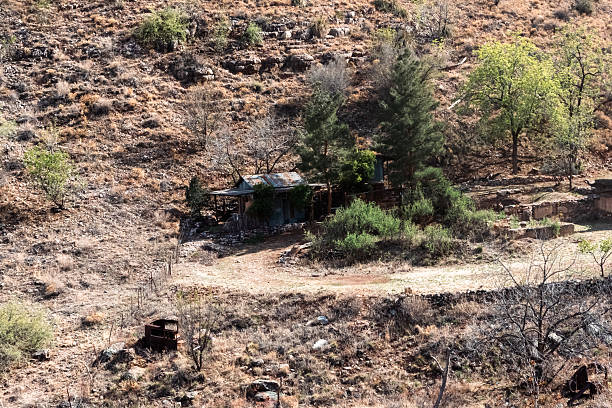 wide angle view of abandoned shack and car on hillside in historic old mining town of Jerome, Arizona