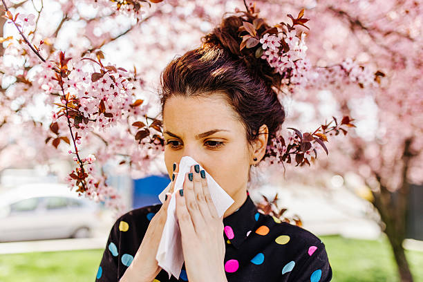 istock Woman sneezing in the blossoming garden 2209422425