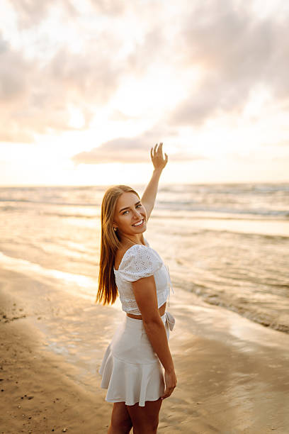 istock Happy young woman walking on sandy beach at sunset. 2209424448