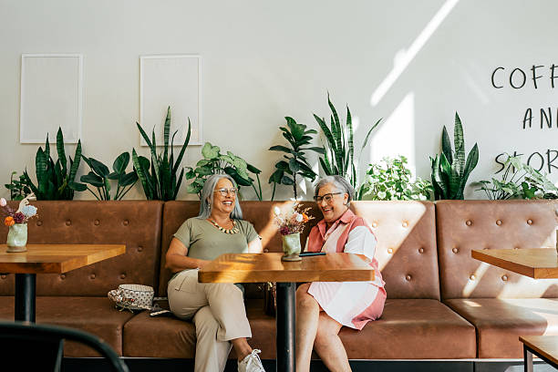 Two female friends chatting while drinking coffee in a cafe